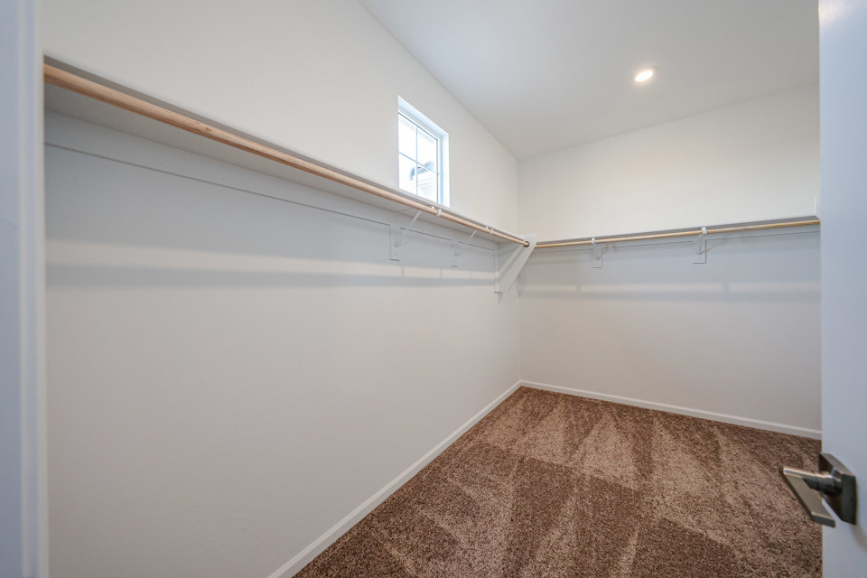 A room with a window and a rug.