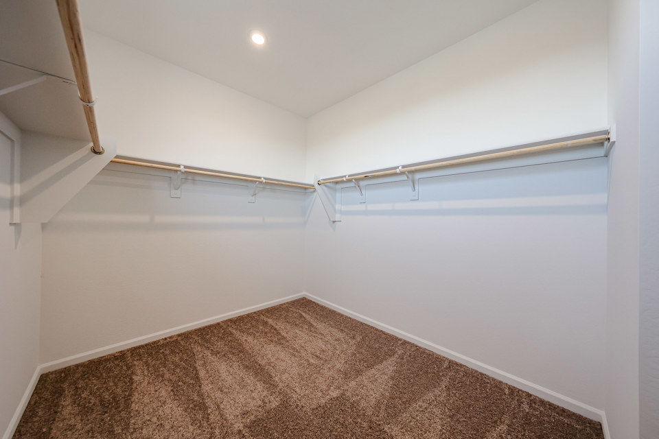 A room with a carpet and a white wall.