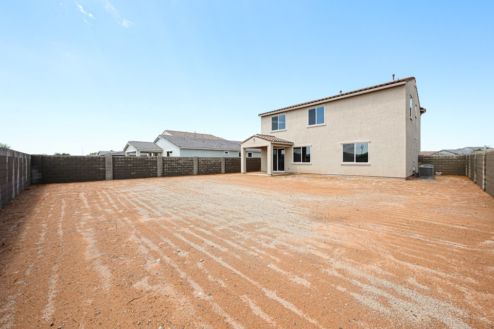 A dirt road leading to a house.