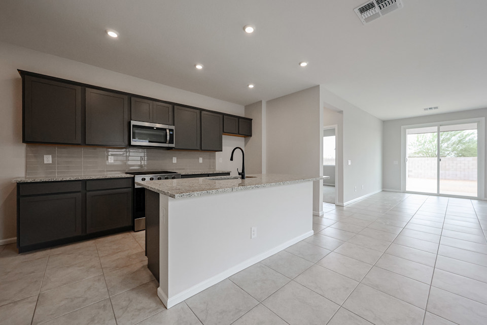 A kitchen with black cabinets.