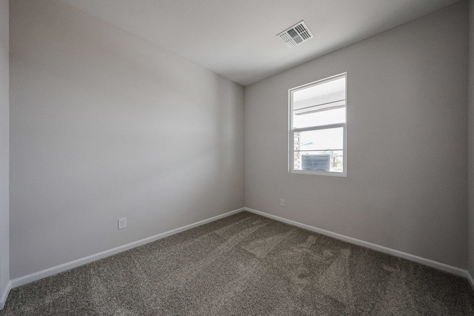 A room with a carpet and a window.