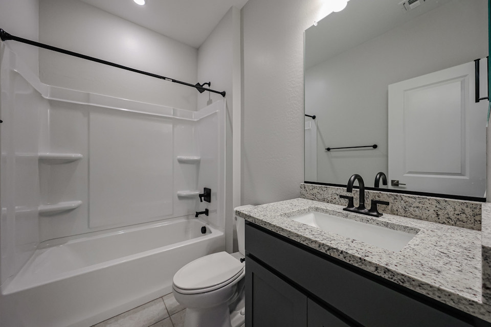A bathroom with a tub sink and toilet.