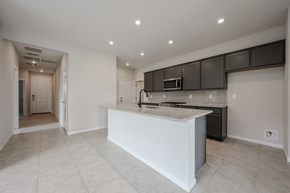 A kitchen with black cabinets.