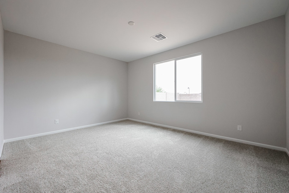 A room with a window and carpet.