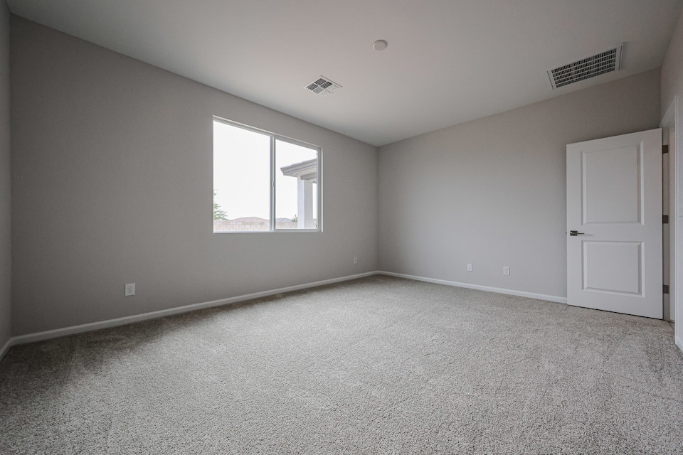 A room with a window and carpet.