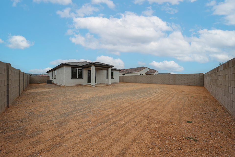 A dirt field with a building in the background.