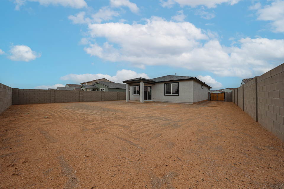 A dirt road with buildings on the side.