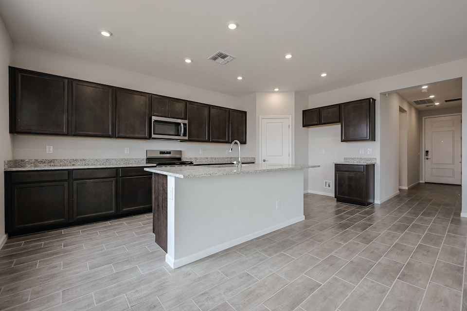 A kitchen with black cabinets.