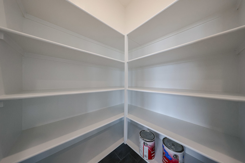 A white shelf with white walls.