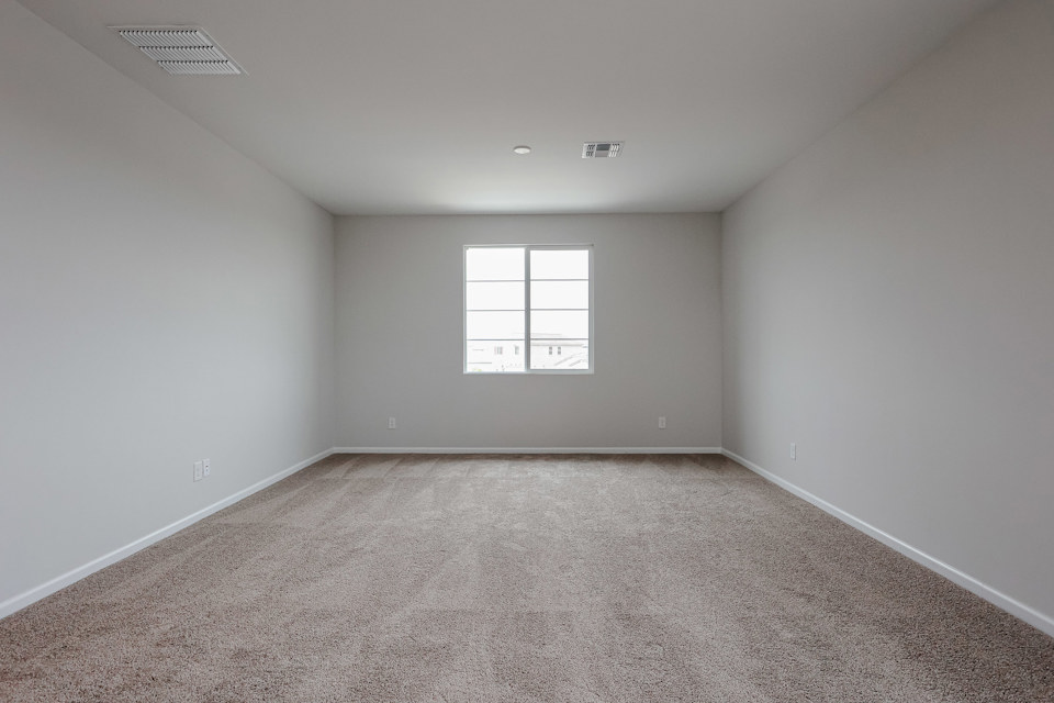 A room with a carpet and a window.