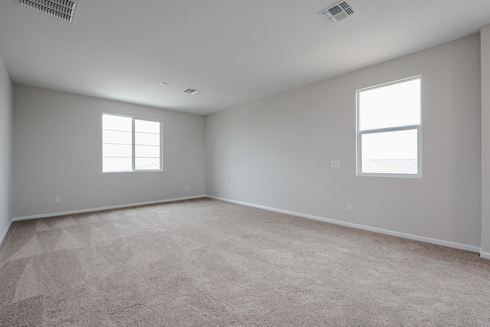 A room with a carpet and windows.