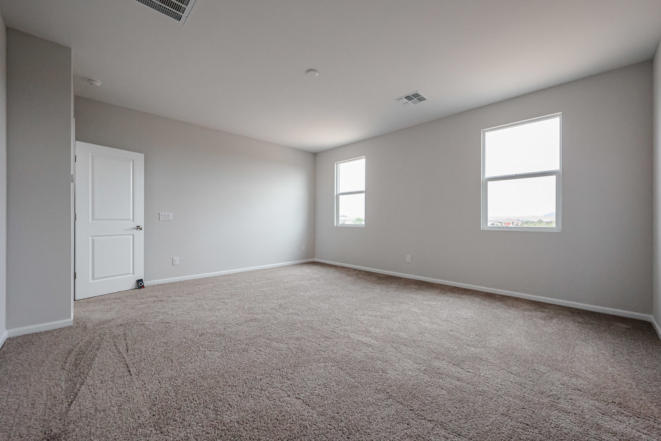 A room with a carpet and a door.