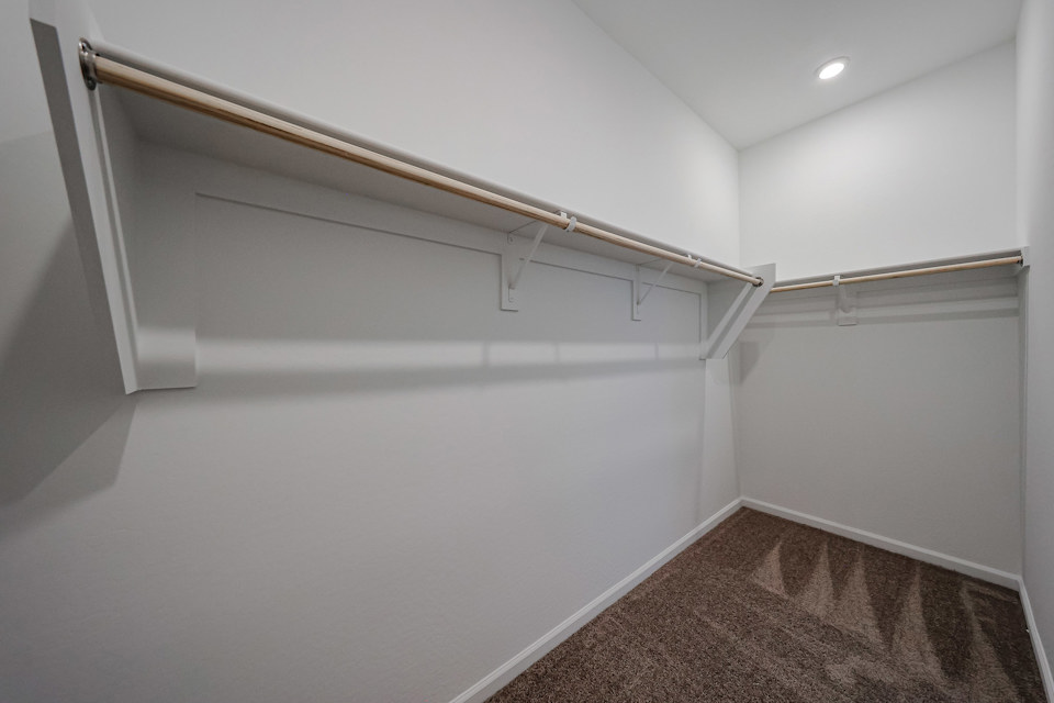 A white wall with a metal bar.