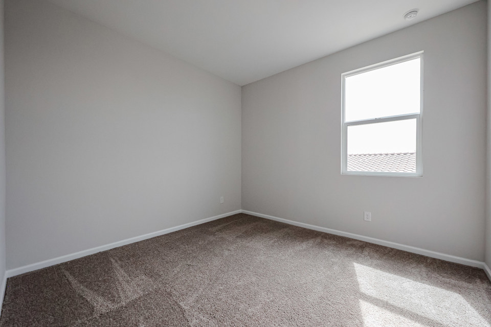 A room with a window and carpet.