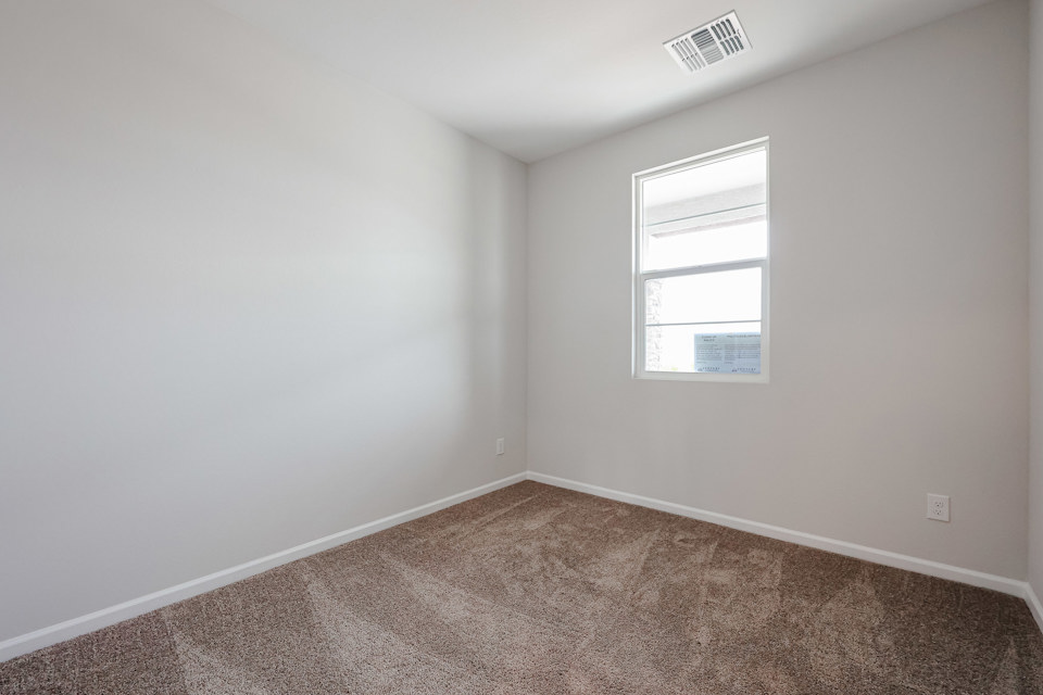 A room with a window and carpet.