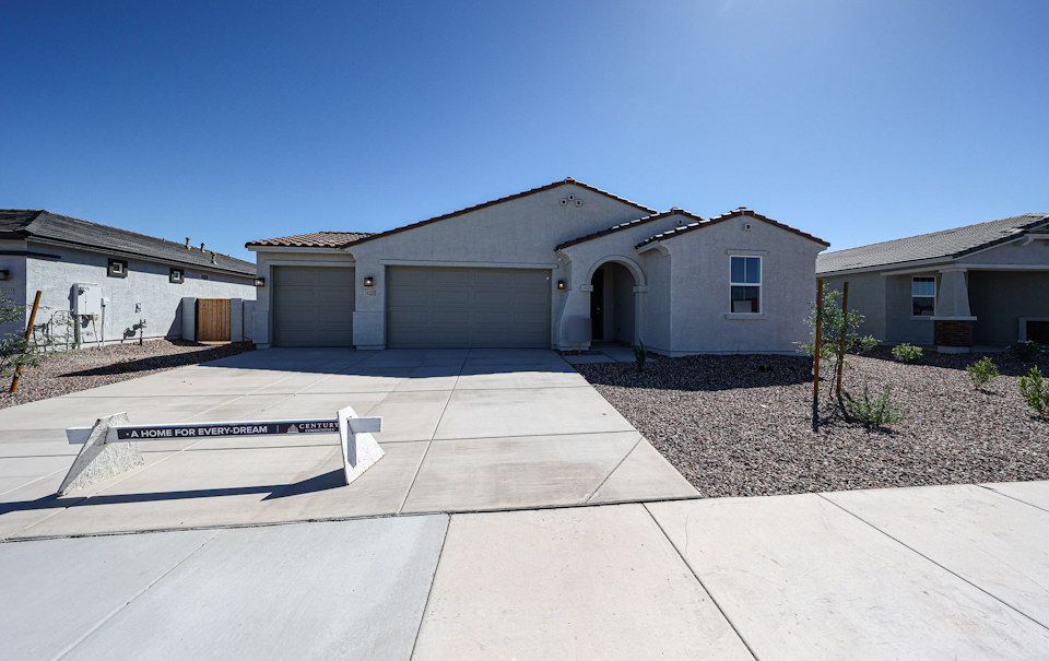 A building with garages and a bench in front.