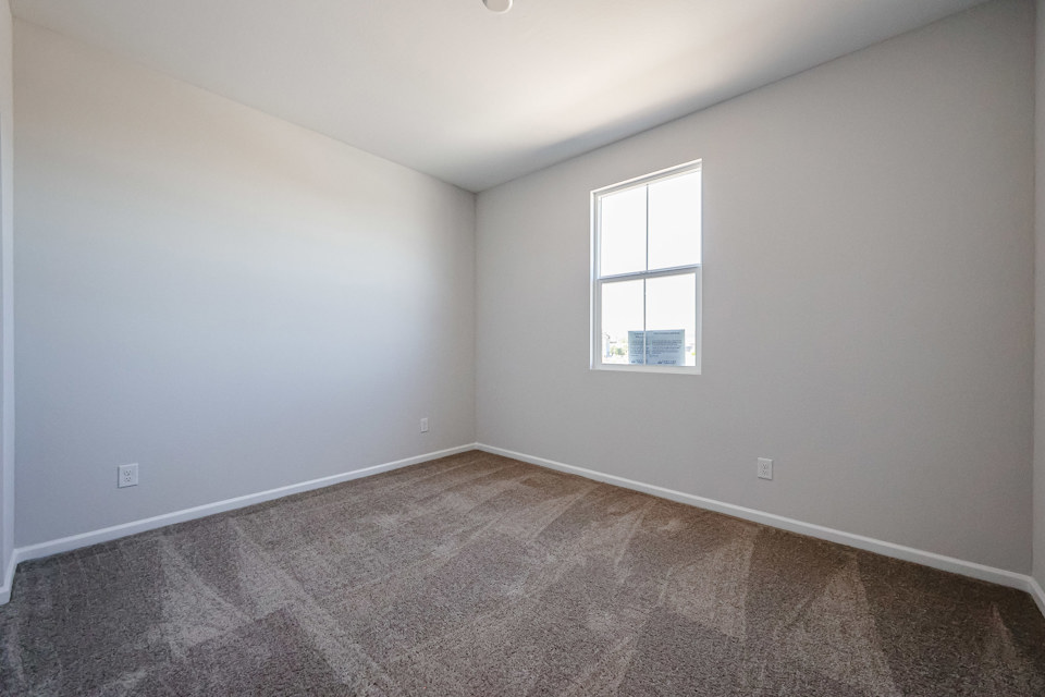 A room with a window and carpet.