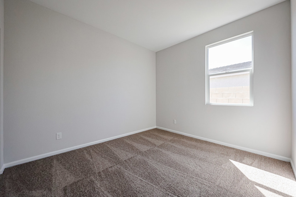 A room with a carpet and a window.