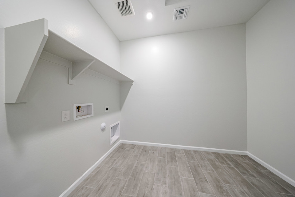 A white room with a wood floor.