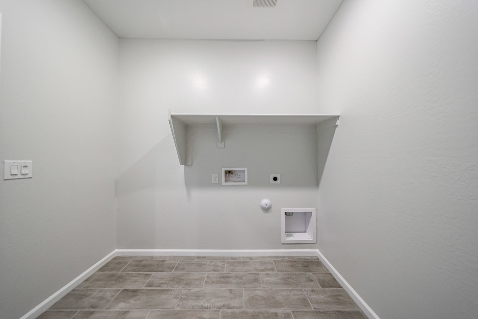 A room with a tile floor and a light on the wall.