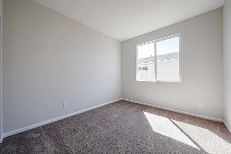 A room with a window and carpet.