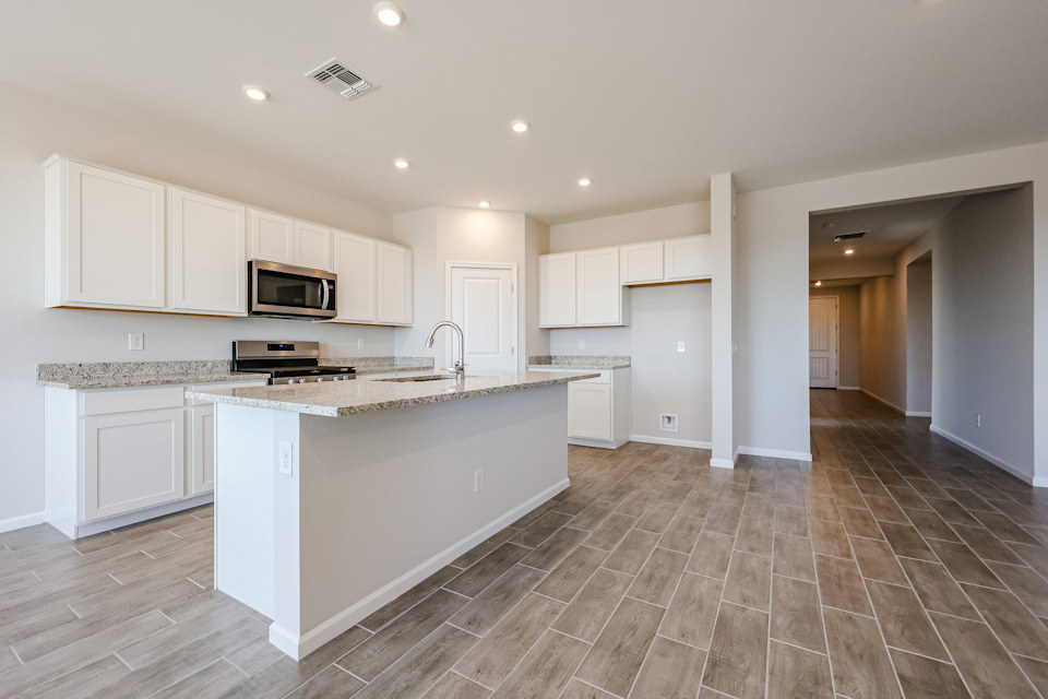 A kitchen with white cabinets.