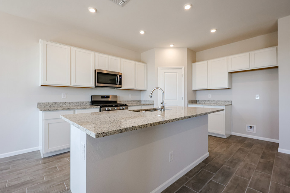 A kitchen with white cabinets.