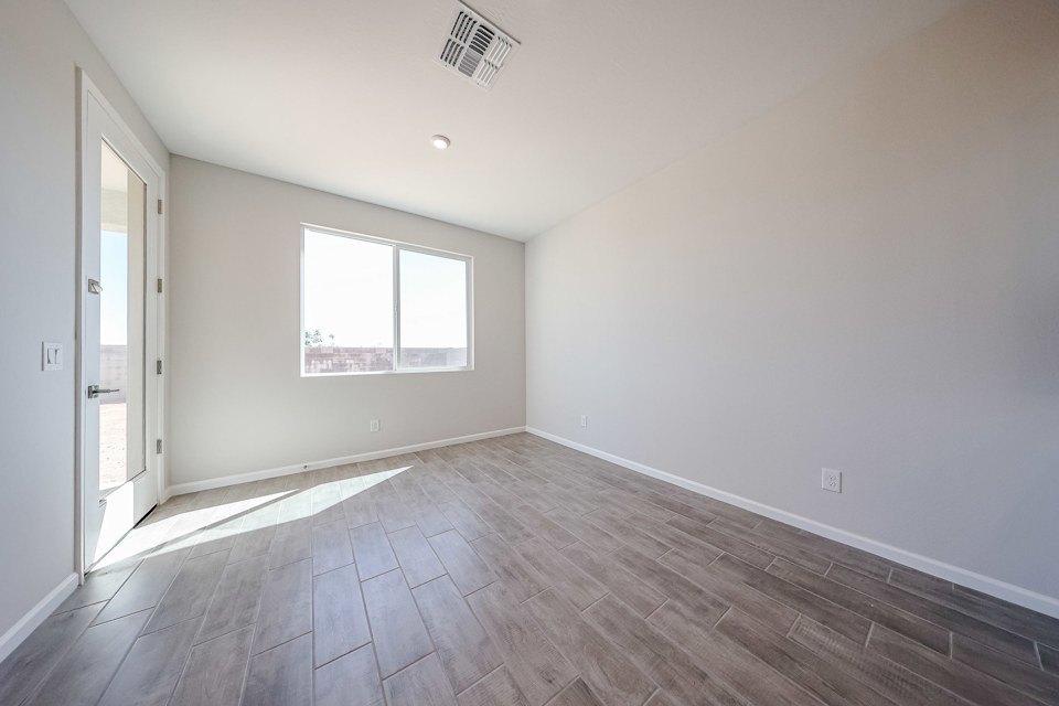 A room with a wood floor and a window.