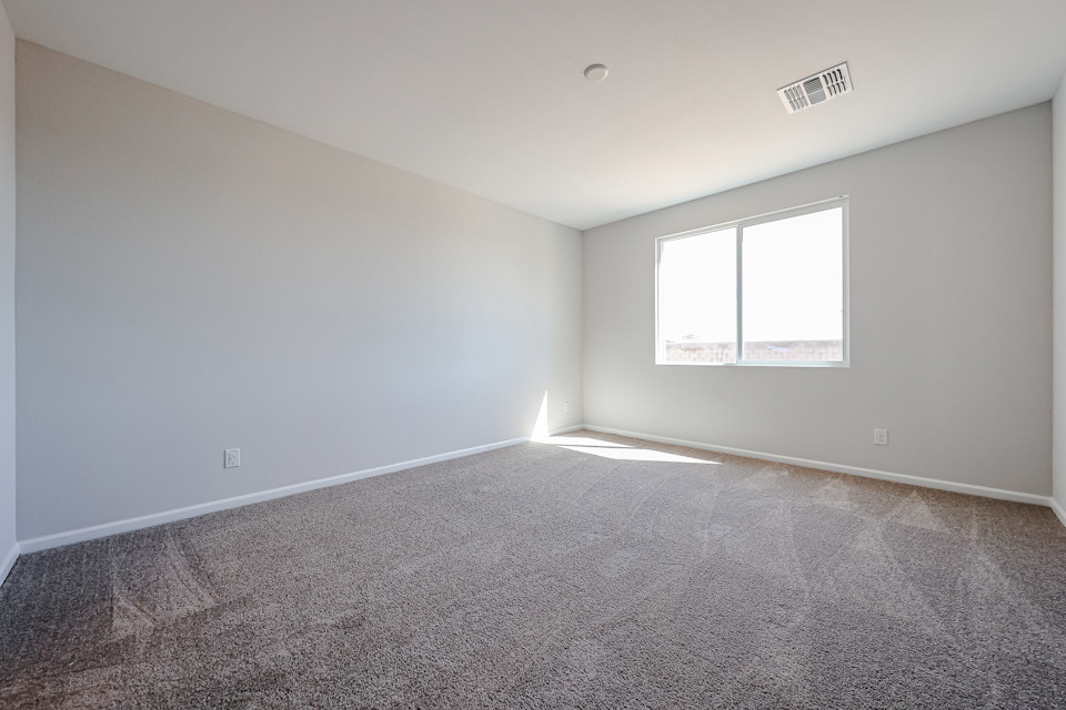 A room with a carpet and a window.