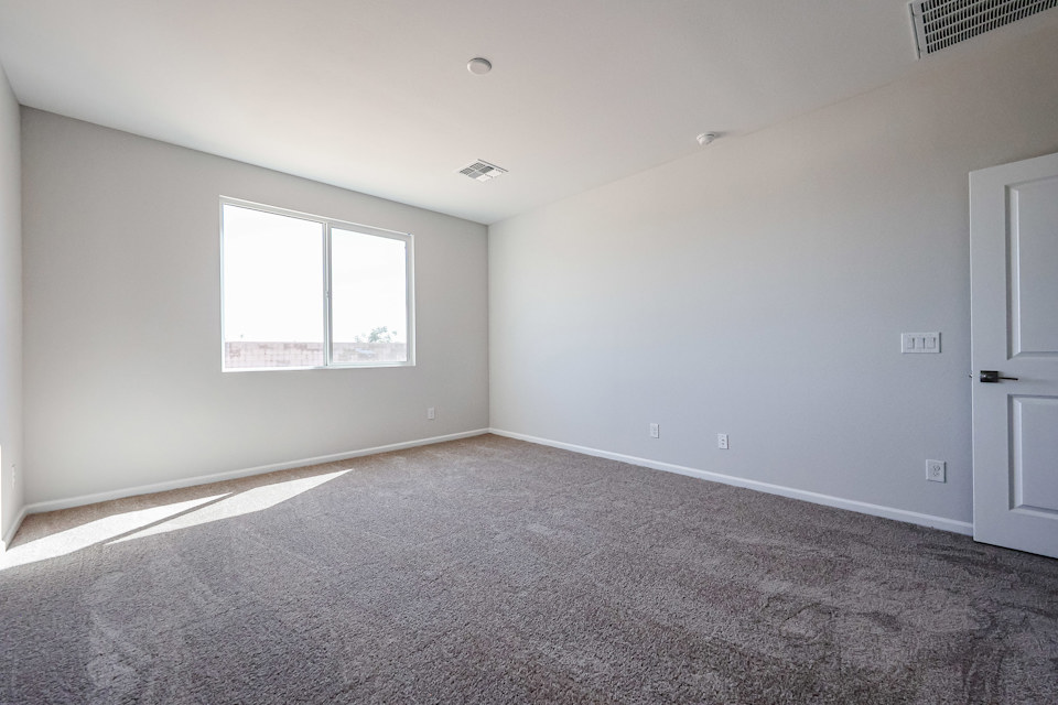 A room with a carpet and a window.