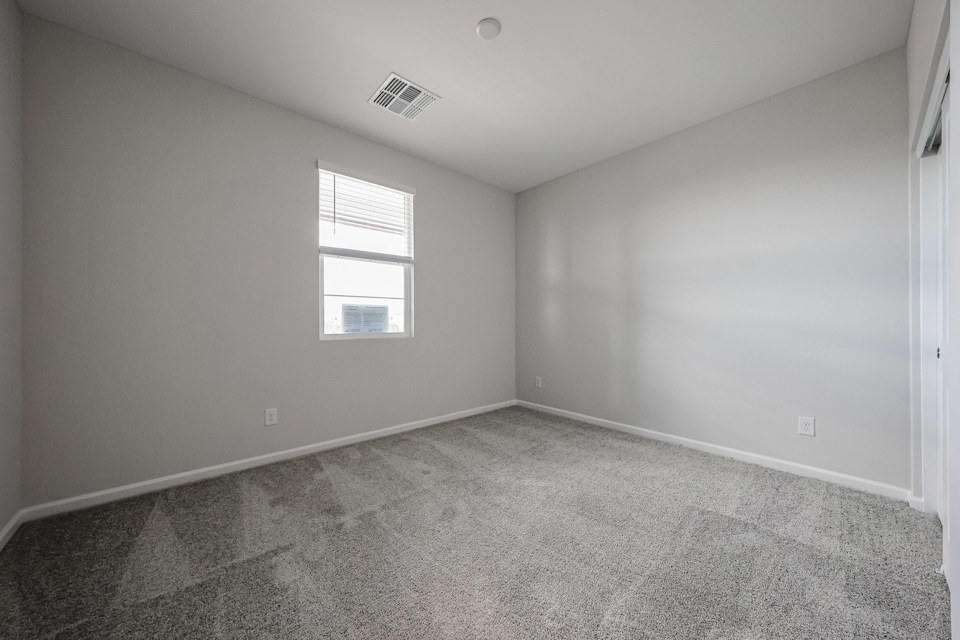 A room with a window and a carpet.