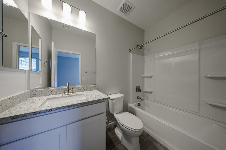 A bathroom with a tub sink and toilet.