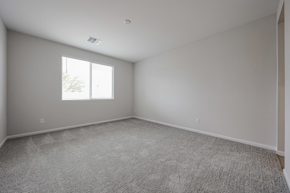 A room with a carpet and a window.