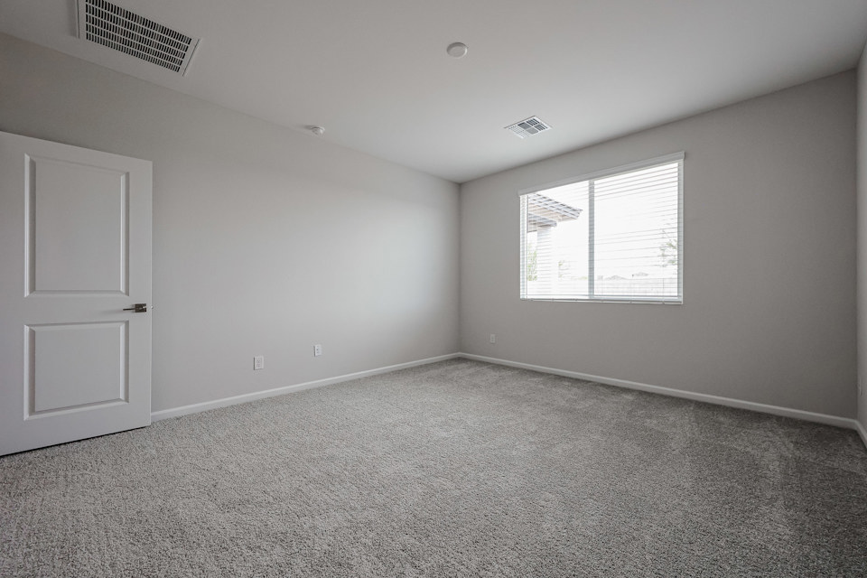 A room with a carpet and a door.