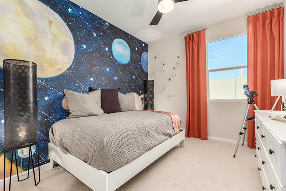 A bedroom with a bed and a large blue wall.