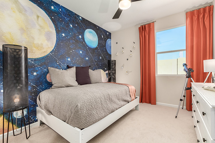 A bedroom with a bed and a large blue wall.