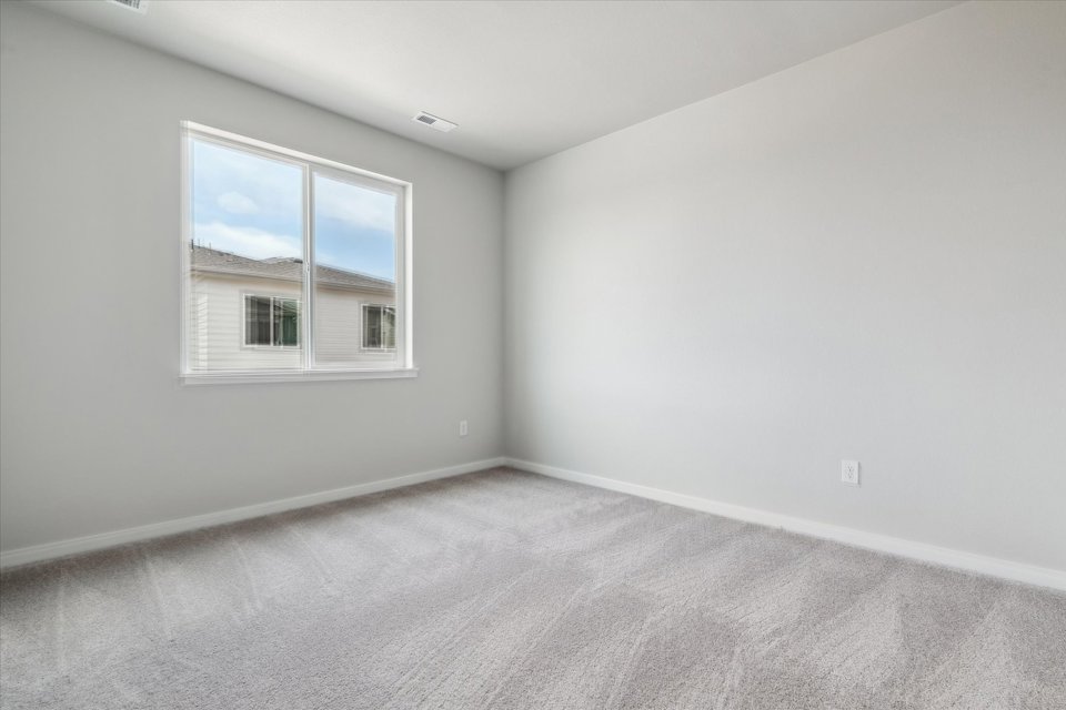 A room with a window and a carpet.