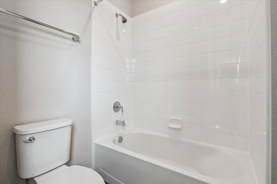 A bathroom with a toilet and bathtub.