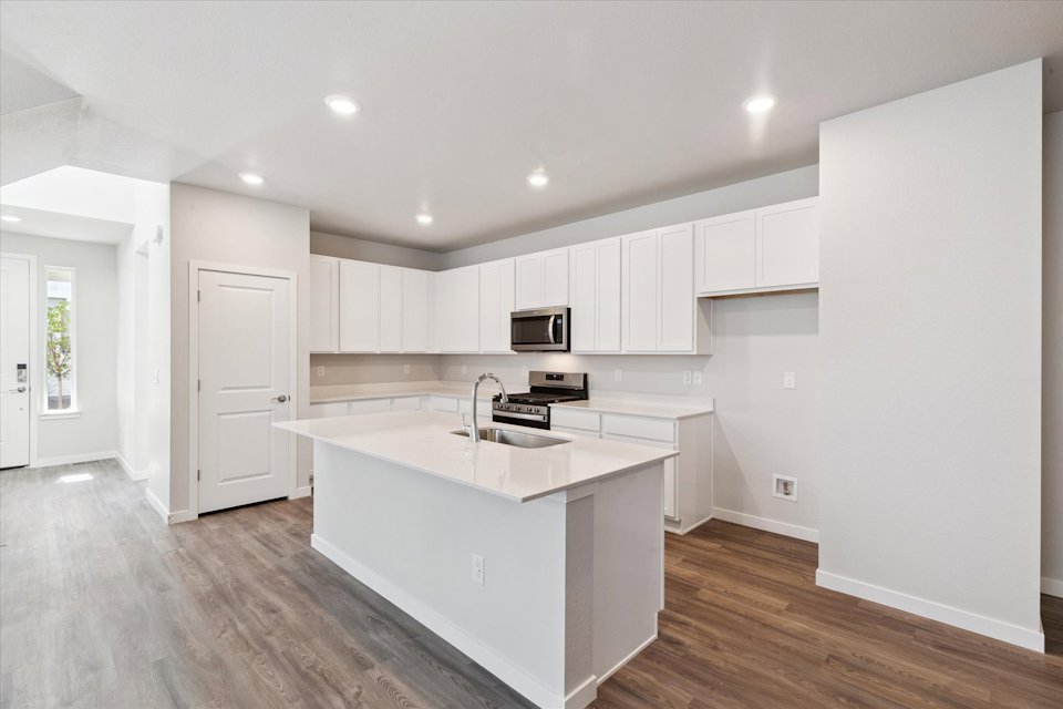 A kitchen with white cabinets.