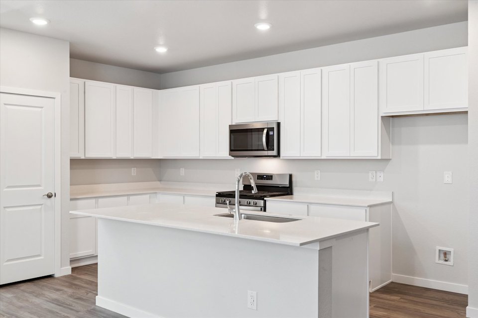 A kitchen with white cabinets.