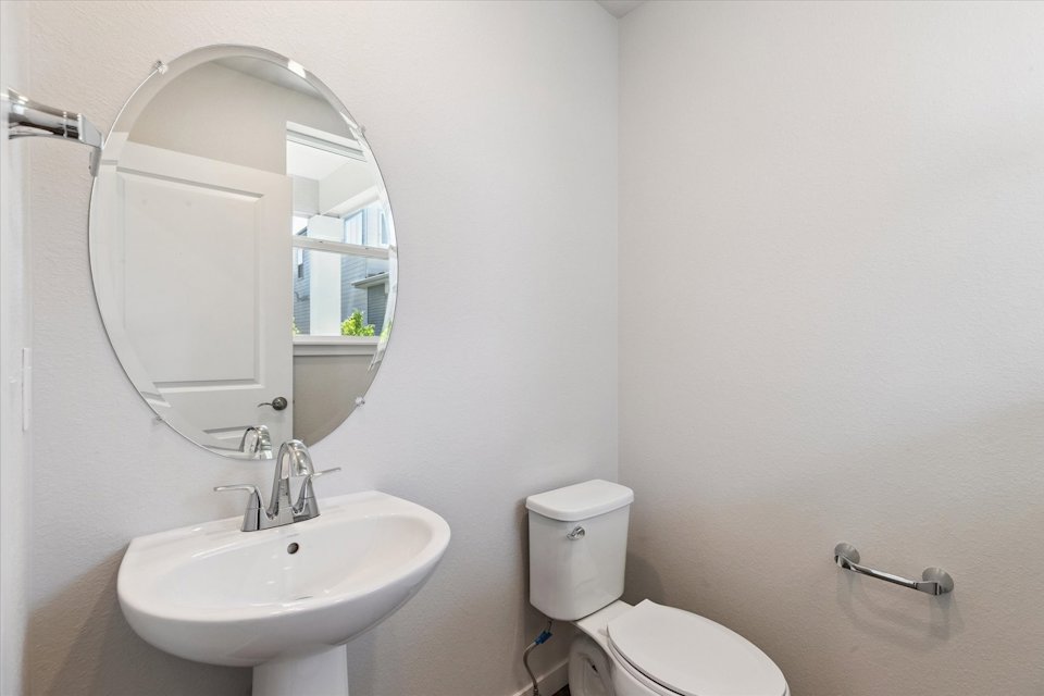 A bathroom with a round mirror.