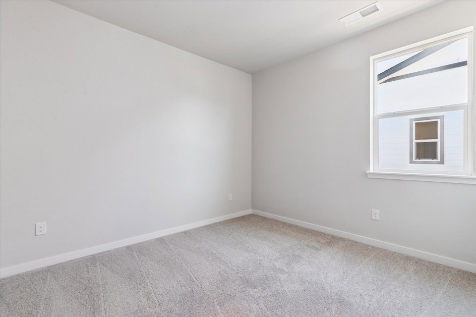 A room with a window and a carpet.