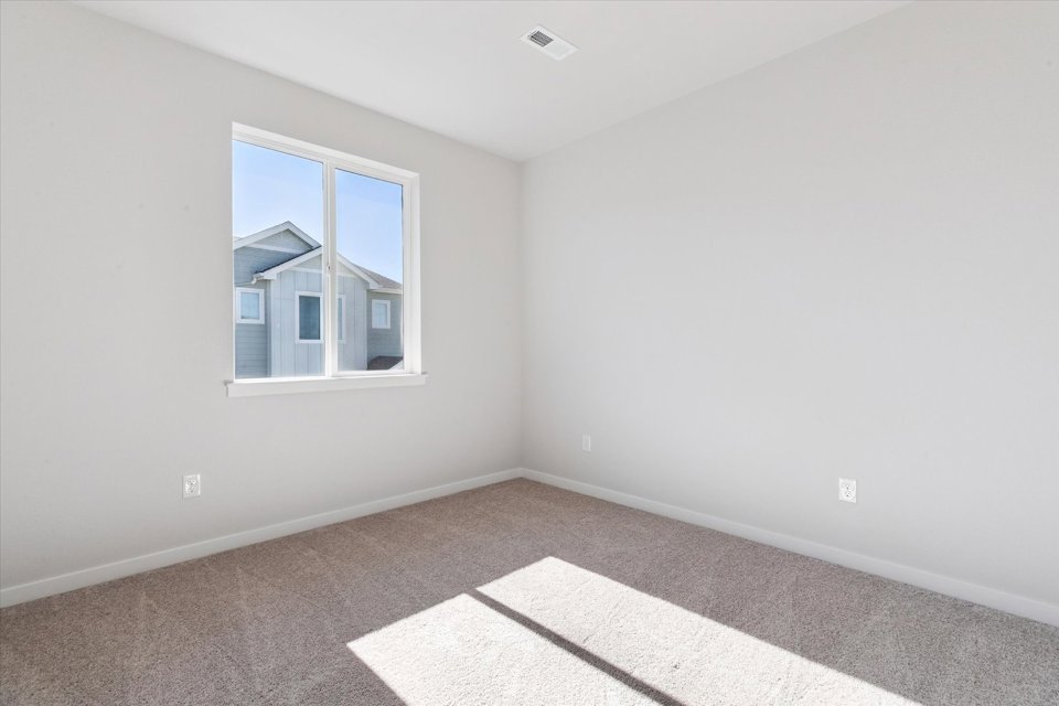 A room with a window and a rug.