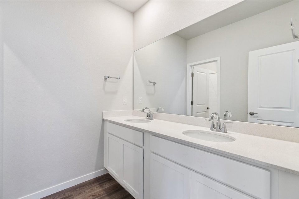 A bathroom with white cabinets.