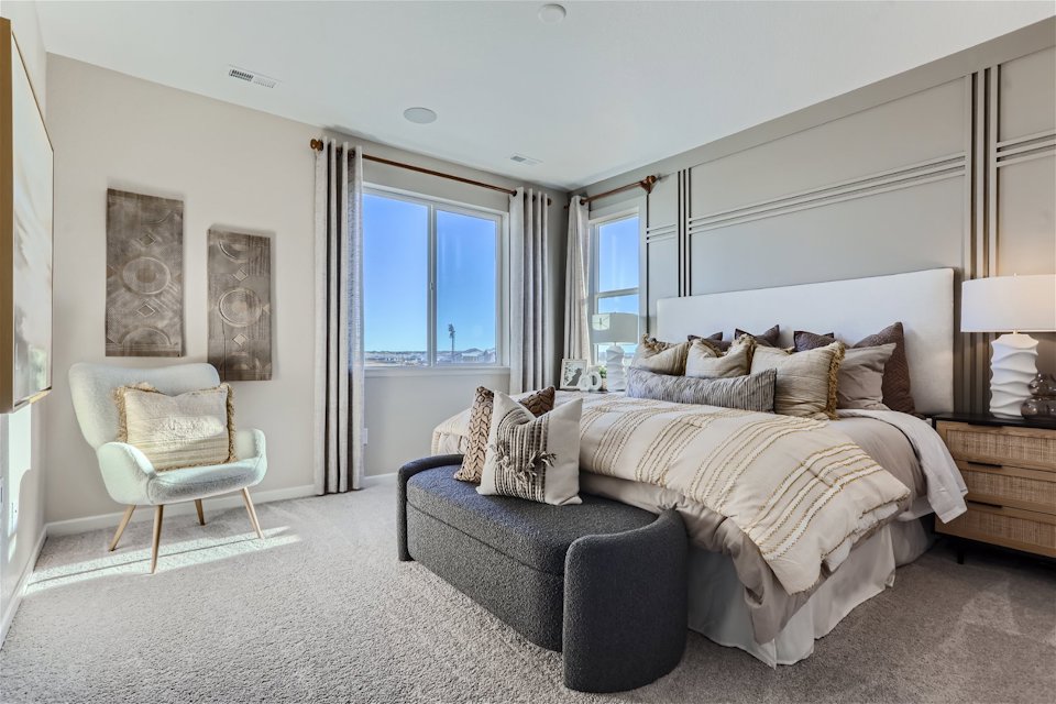 A bedroom with a bed and a chair.