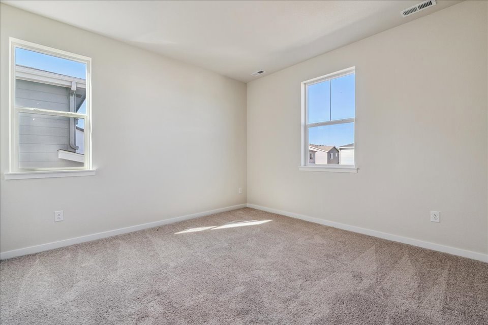 A room with a carpet and windows.