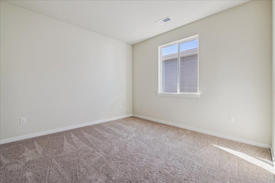 A room with a window and carpet.