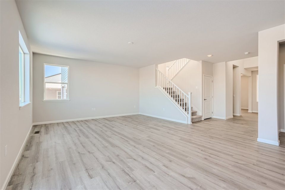 A large empty room with a wood floor and white walls.