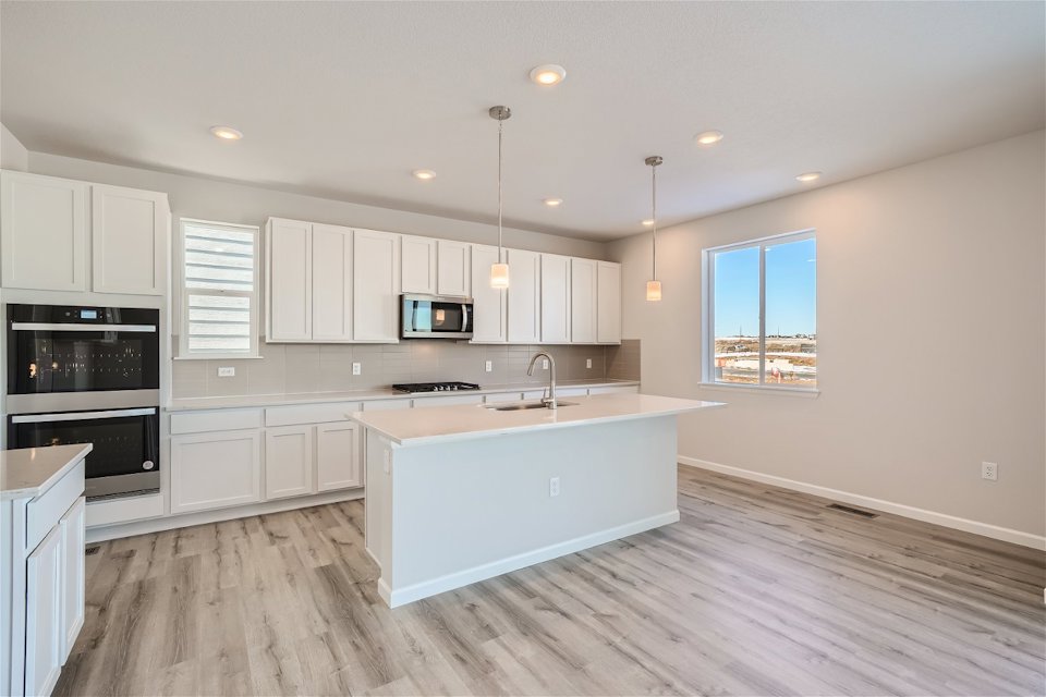 A kitchen with white cabinets.