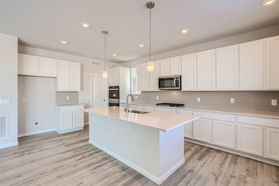A kitchen with white cabinets.